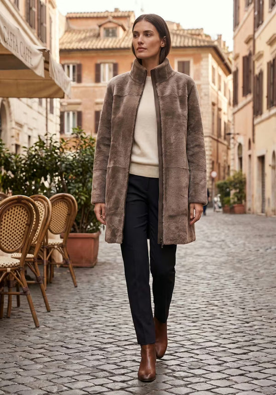 Women’s sheepskin coat in the fur side, worn open in grey-brown with zip fastening and slim fit.