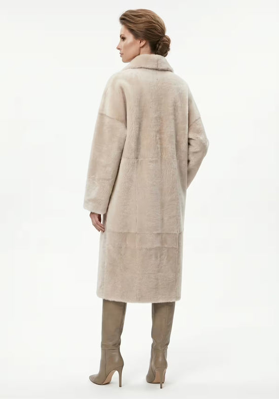 Shearling sheepskin coat in cream, shown worn by a woman from the back.