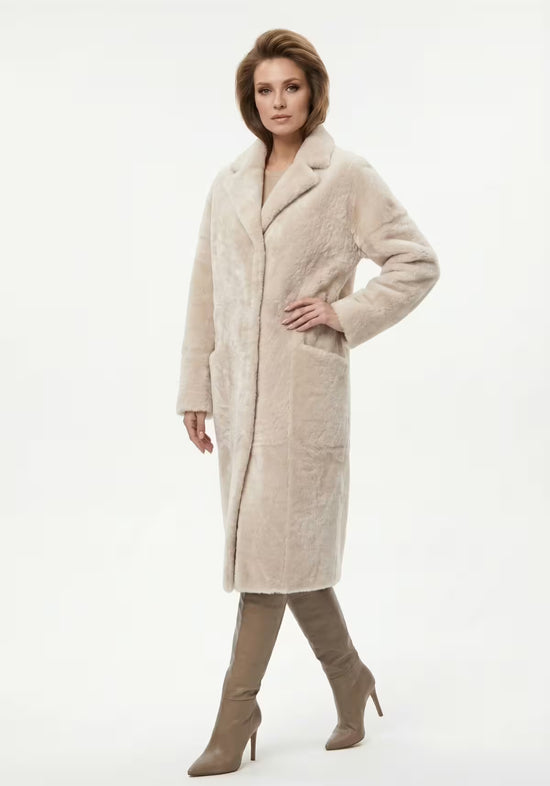 Shearling sheepskin coat in cream, shown worn by a woman in side view.