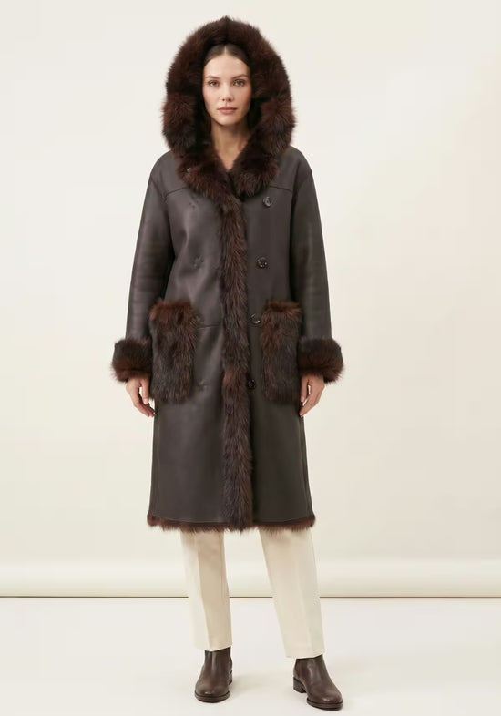 Brown reversible sheepskin coat for women shown from the front with hood and trim.