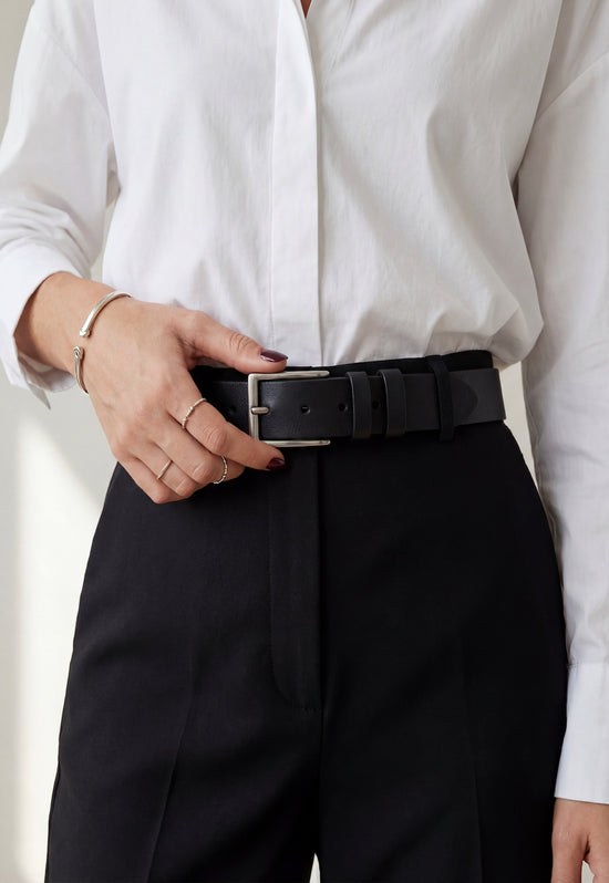 Black leather belt made from buffalo leather worn with a white women's shirt and black trousers