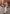Beige men's leather jacket in suede in a street view with white trousers