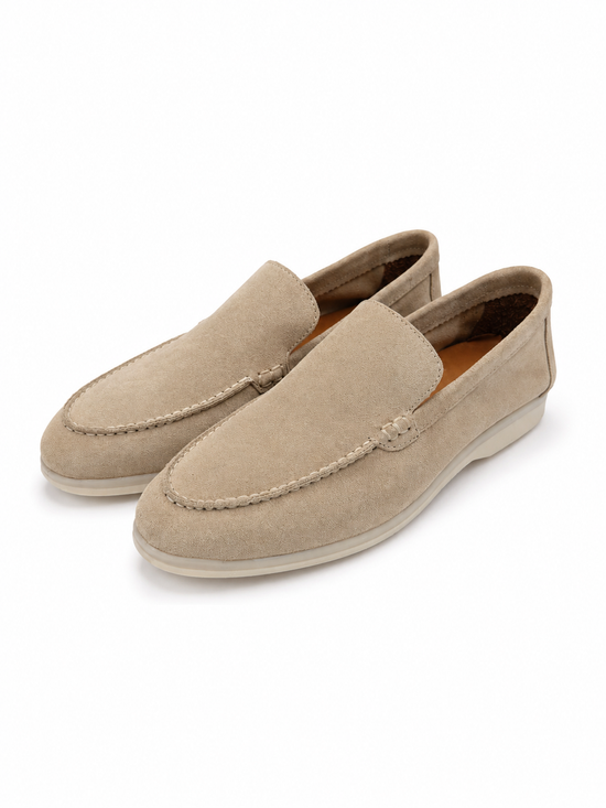Beige men's loafers in calf suede shown as a pair in an angled front view.