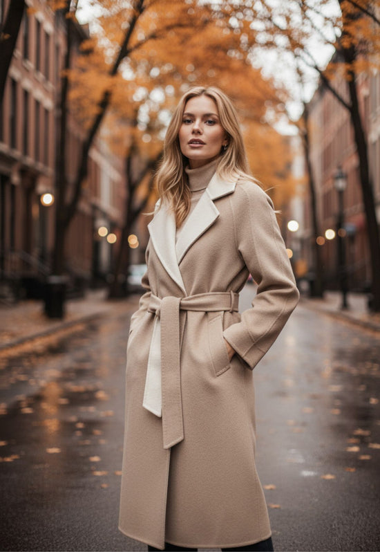 Beige women’s coat made from cashmere wool, shown in a side view and worn with a belt outdoors.