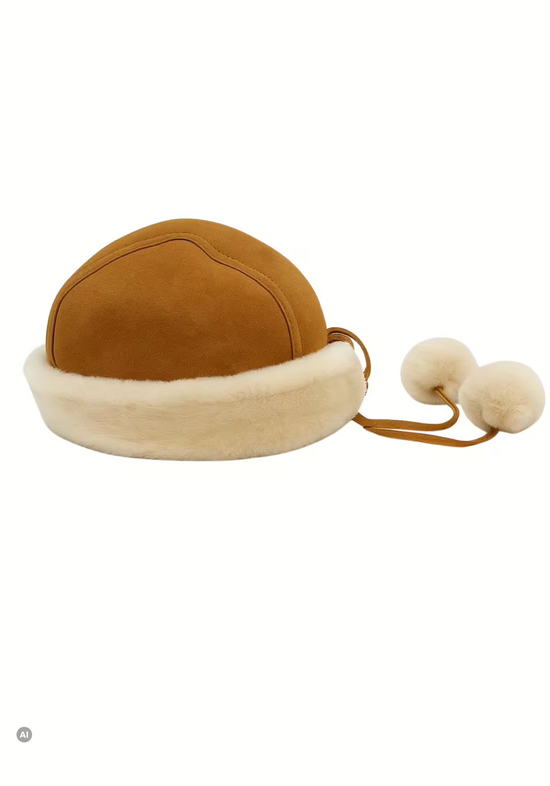 Freestanding women's sheepskin hat in whisky with Merino wool, fur trim and ties with pom-poms.