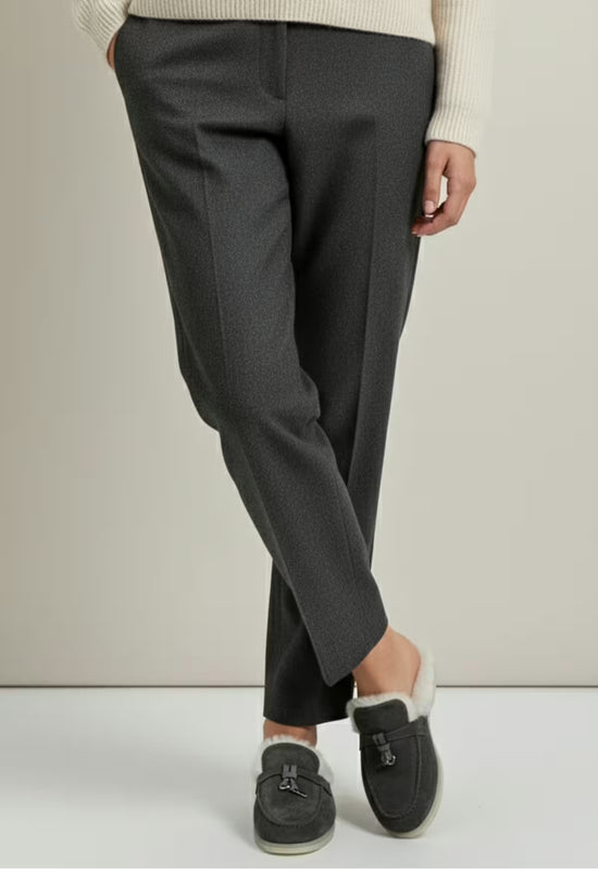 Women's sheepskin mules in anthracite shown worn with dark trousers and visible fur lining.