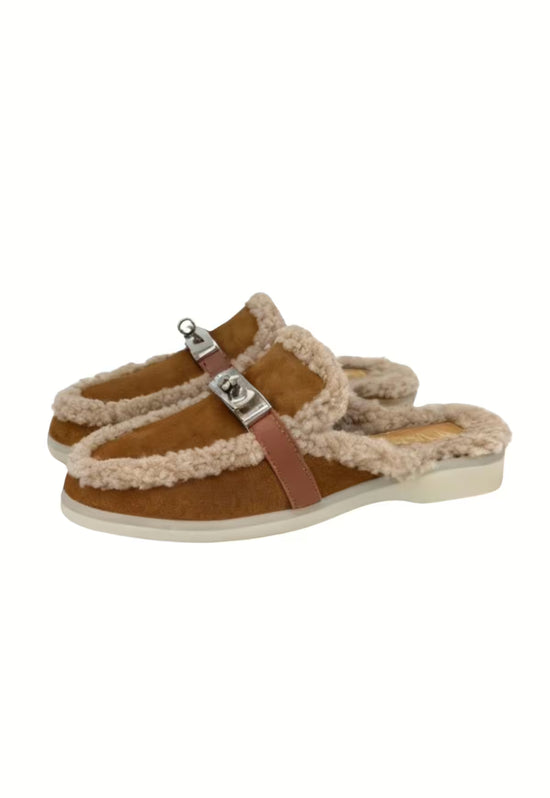 Brown women's sheepskin mules in an angled view with side strap and sole.