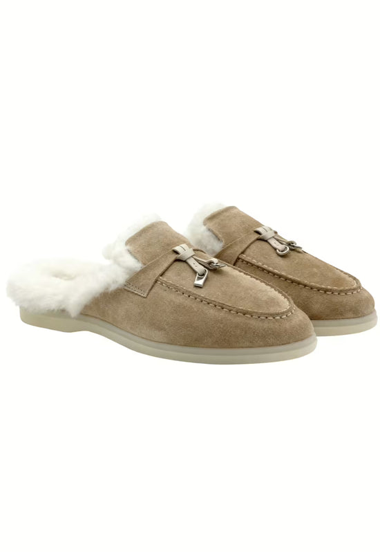 Pair of women's sheepskin mules in sand, shown at an angled view with open heel and fur trim.