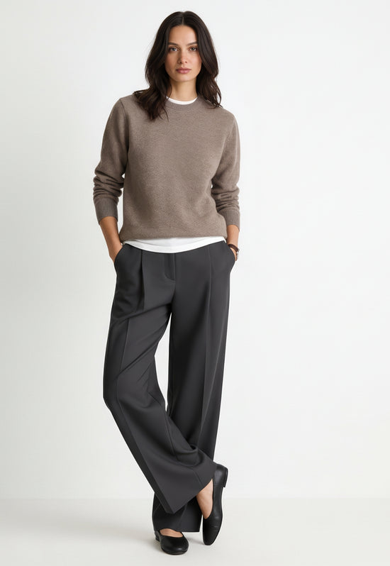 Women's cashmere jumper in taupe, worn with a relaxed fit and long sleeves.