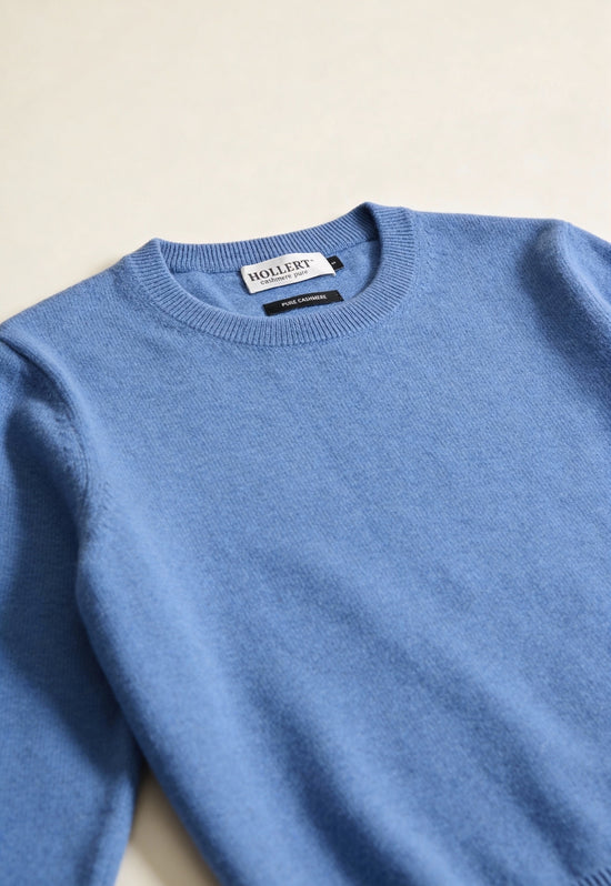 Light blue cashmere sweater shown in detail at the crew neck and fine knit texture.