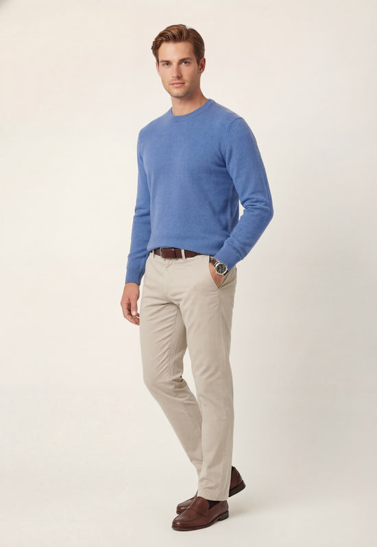 Men's light blue cashmere sweater shown worn on a model with light trousers.