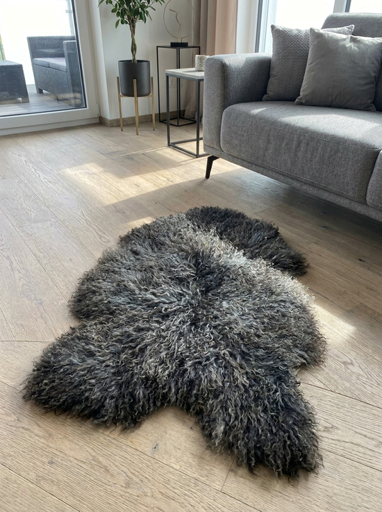 Gotland sheepskin with a curly pile spread out on a light wooden floor.