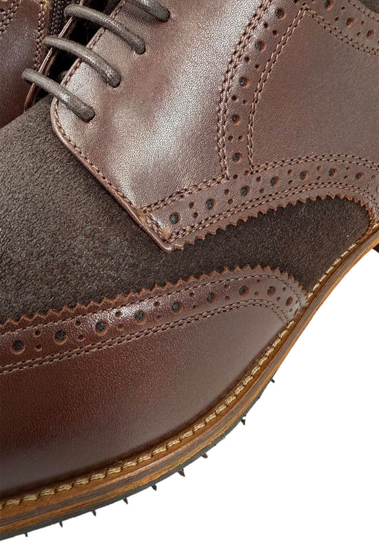 Detail of the men's street shoe in sheepskin and leather, brown, with brogue perforation