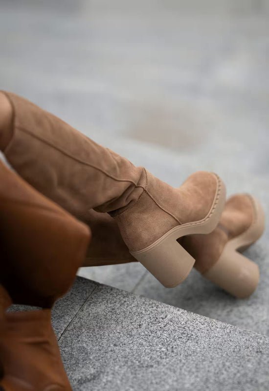 Detail view of brown women's suede boots with a block heel and profiled sole.