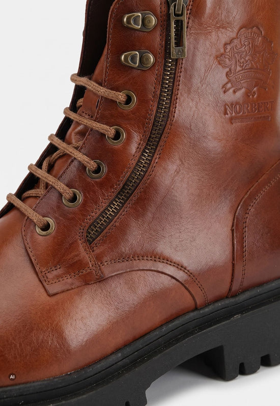 Detail of the brown men's sheepskin ankle boot with zip, lace eyelets and leather embossing.