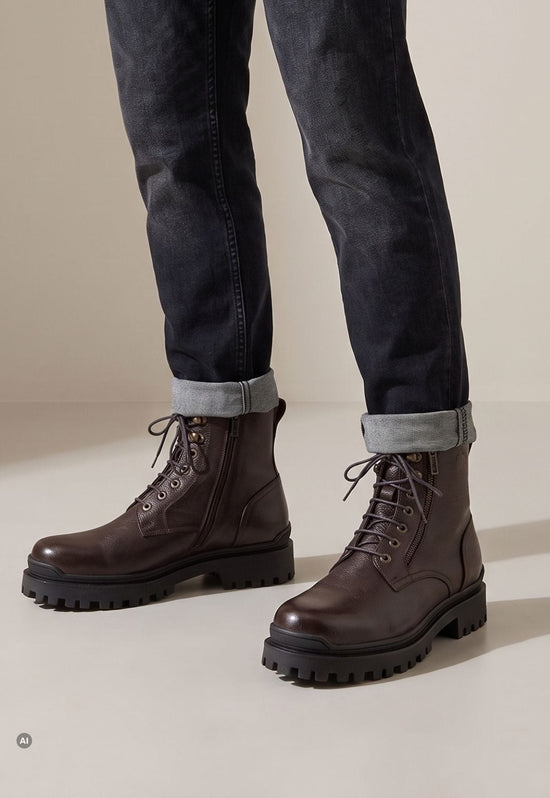 Dark brown men’s sheepskin ankle boots in leather, worn with turned-up jeans.