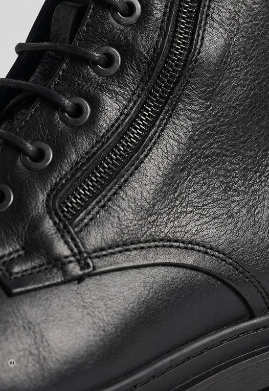 Detail of the black men's ankle boot in leather with a zip fastening and fine grain texture.