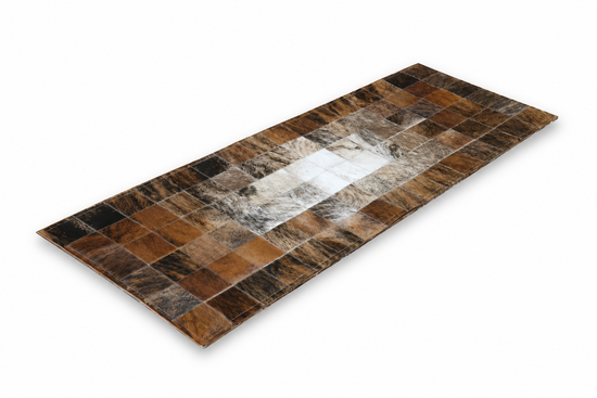 Long cowhide rug in brown, white and black, isolated on a white background
