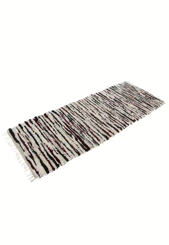 Sheeps wool rug in multicolour isolated in an angled view with fringe