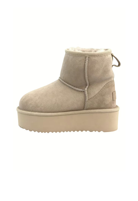 Beige women's winter boot in sheepskin, shown from the side with platform sole