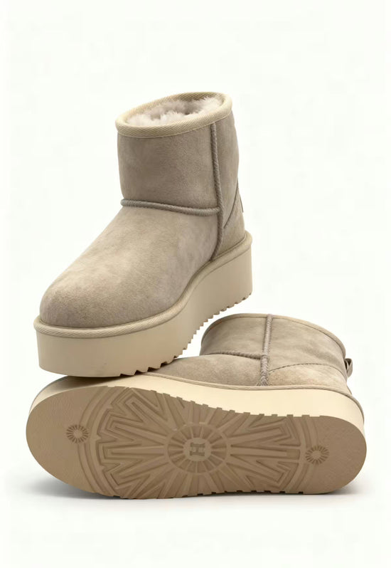 Beige sheepskin winter boot for women with tread sole, plus the underside of a second shoe