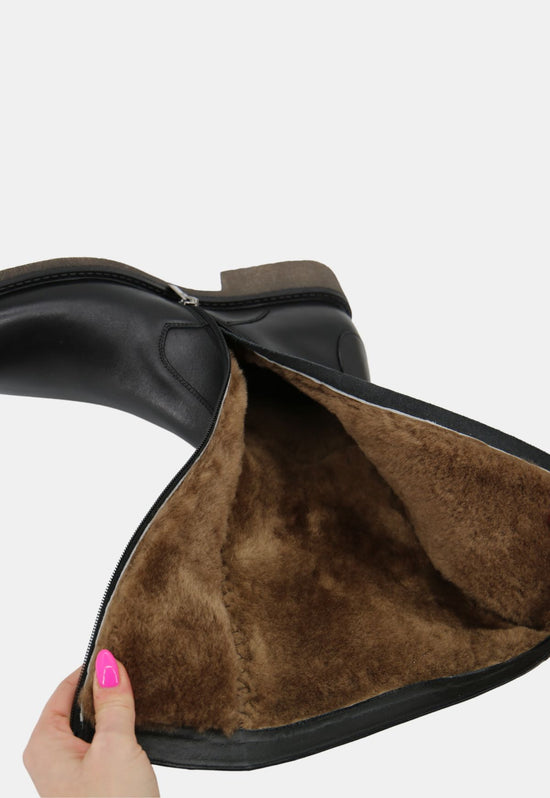 Close-up of a black sheepskin men's winter boot with the shaft turned open.