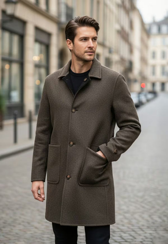 Brown men's wool coat in cashmere and wool, worn open in a street scene with one hand in the pocket.